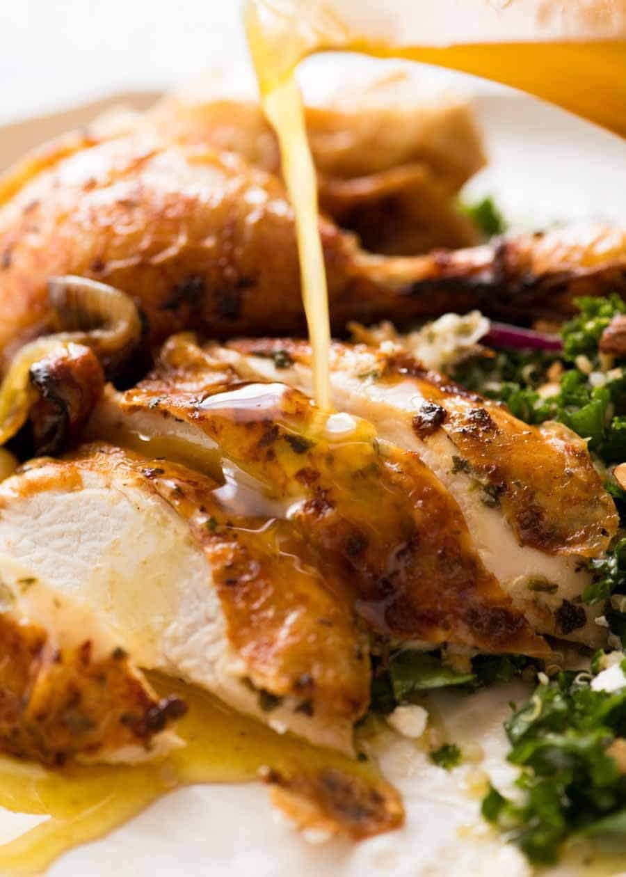 Lemon butter white wine pan juices being poured over sliced Roast Chicken.