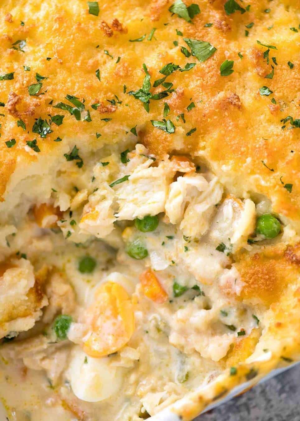 Close up of Fish Pie in white baking dish showing creamy filling with fish flakes